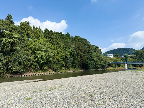青空と白い雲の下、広い砂利の河原が広がる川の風景